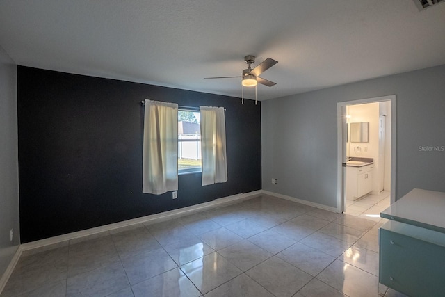 tiled empty room featuring ceiling fan