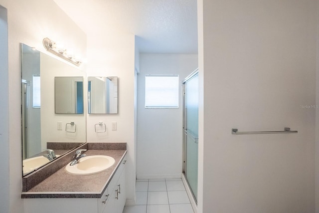 bathroom featuring walk in shower, vanity, tile patterned flooring, and a textured ceiling