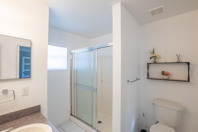 bathroom with tile patterned flooring, toilet, vanity, and walk in shower