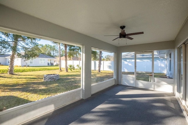 unfurnished sunroom featuring ceiling fan