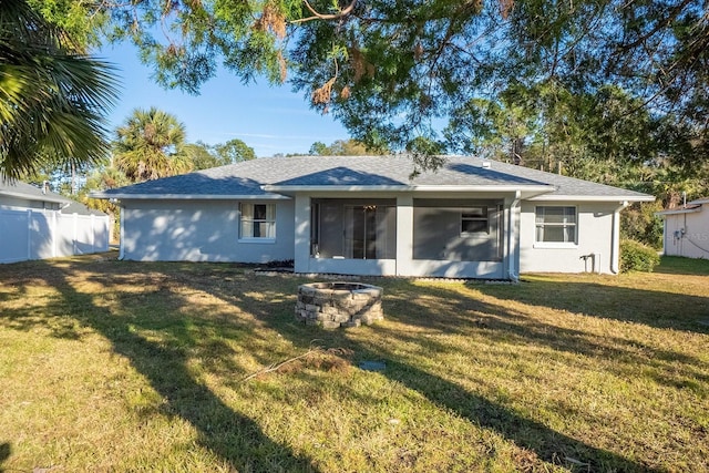 back of property featuring a yard and a fire pit