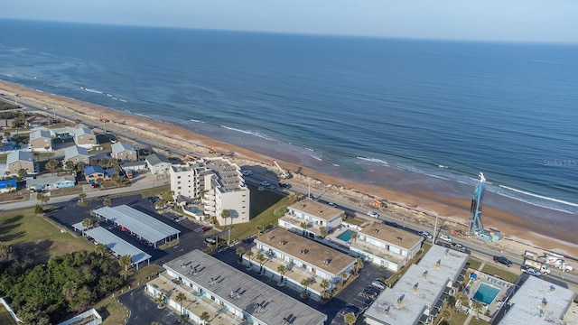 bird's eye view with a water view and a beach view