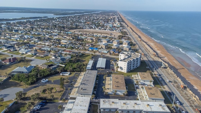 drone / aerial view with a water view and a beach view