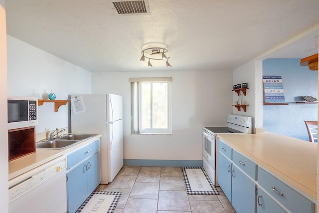 kitchen with light countertops, white appliances, a sink, and visible vents