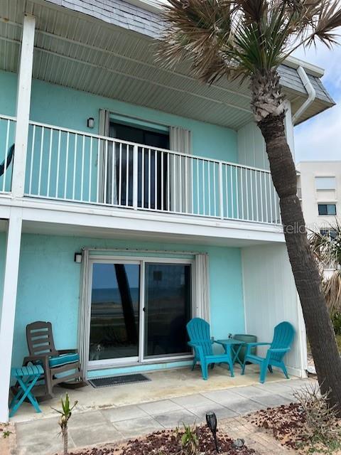 rear view of house featuring a balcony and stucco siding