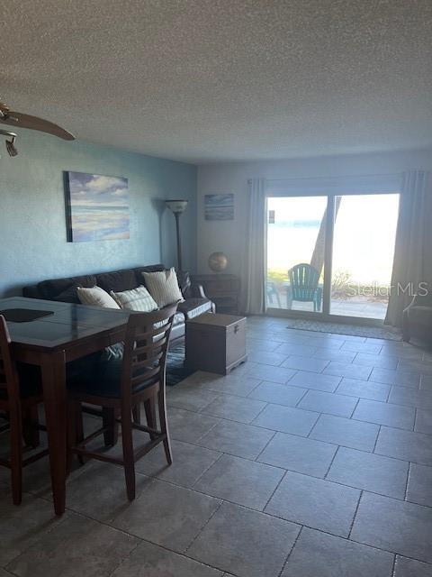 dining area with a ceiling fan and a textured ceiling