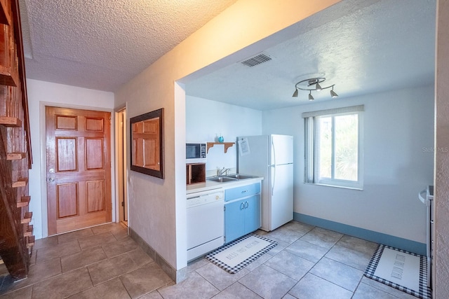 kitchen featuring white appliances, baseboards, visible vents, light countertops, and a sink