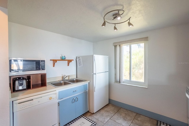 kitchen featuring white appliances, light tile patterned floors, baseboards, light countertops, and a sink