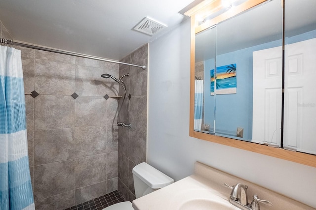 full bath featuring toilet, visible vents, a tile shower, and vanity