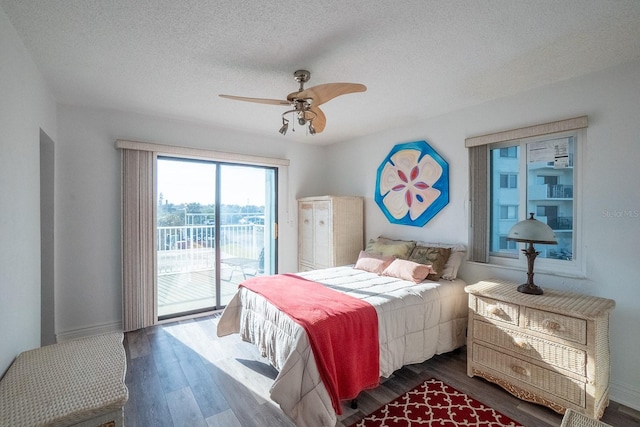 bedroom featuring a textured ceiling, access to outside, dark wood-type flooring, and ceiling fan