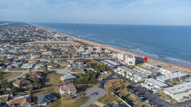 birds eye view of property with a water view and a beach view