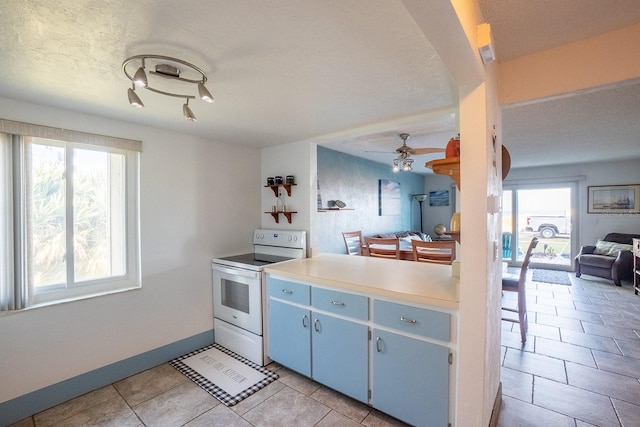 kitchen featuring open floor plan, light countertops, electric range, and plenty of natural light