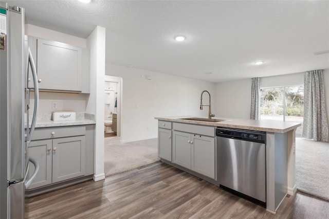 kitchen featuring gray cabinets, appliances with stainless steel finishes, sink, dark wood-type flooring, and a textured ceiling