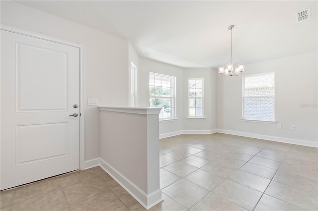 interior space featuring a notable chandelier, light tile patterned floors, and a wealth of natural light