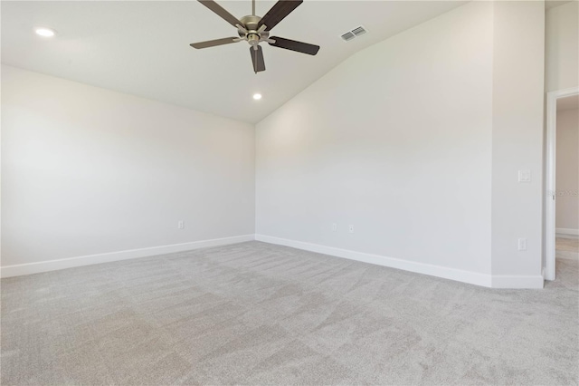 spare room featuring lofted ceiling, light colored carpet, and ceiling fan