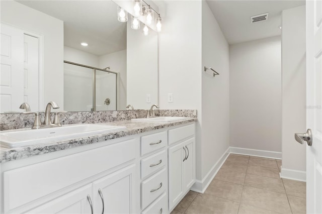 bathroom featuring tile patterned floors, a shower with shower door, and vanity