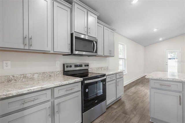 7 Whitcock Ln, Palm Coast, FL 32164 - kitchen featuring stainless steel appliances, vaulted ceiling, gray cabinets, dark wood finished floors, and baseboards