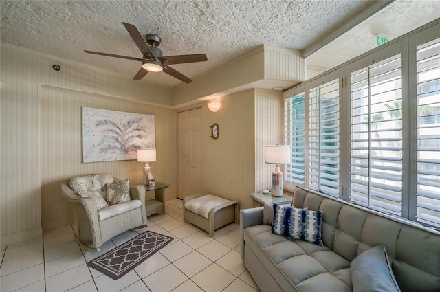 living room with ceiling fan, light tile patterned floors, and a textured ceiling