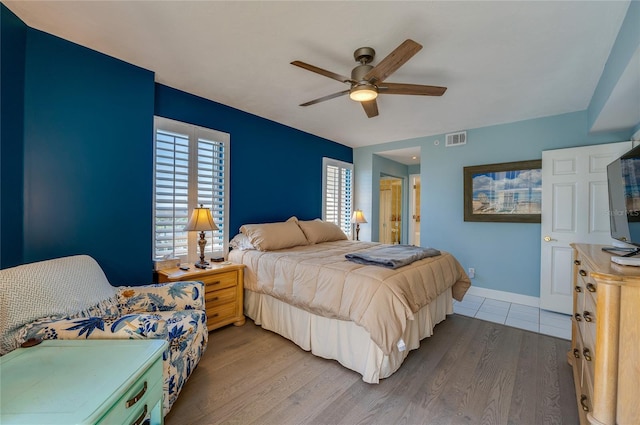 bedroom featuring ceiling fan, ensuite bathroom, and light hardwood / wood-style floors