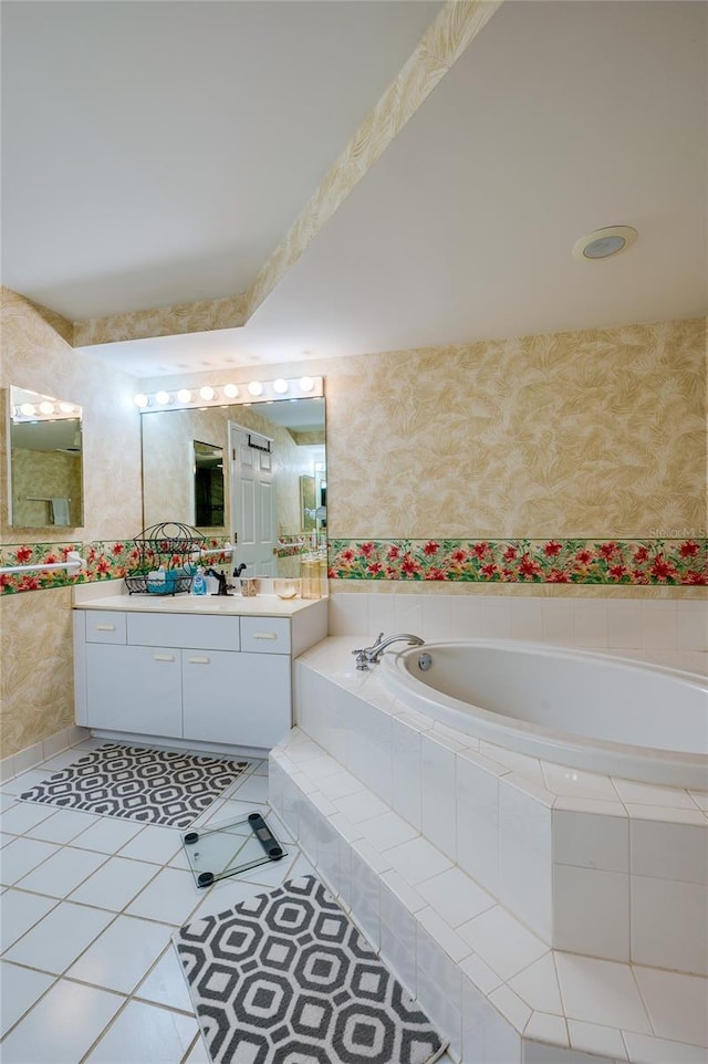 bathroom featuring vanity, tile patterned flooring, and tiled bath