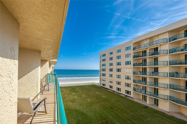 balcony featuring a view of the beach and a water view