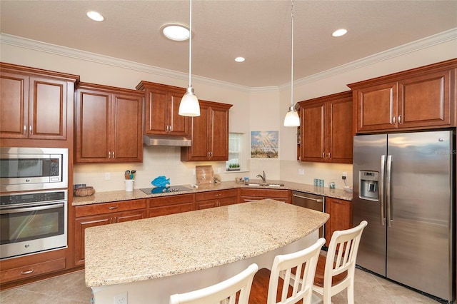 kitchen featuring stainless steel appliances, a breakfast bar area, sink, and hanging light fixtures