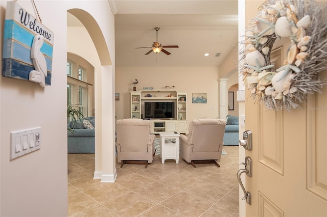 tiled living room featuring high vaulted ceiling, ceiling fan, and ornate columns