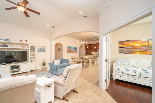 living room featuring high vaulted ceiling, hardwood / wood-style flooring, ornamental molding, and ceiling fan