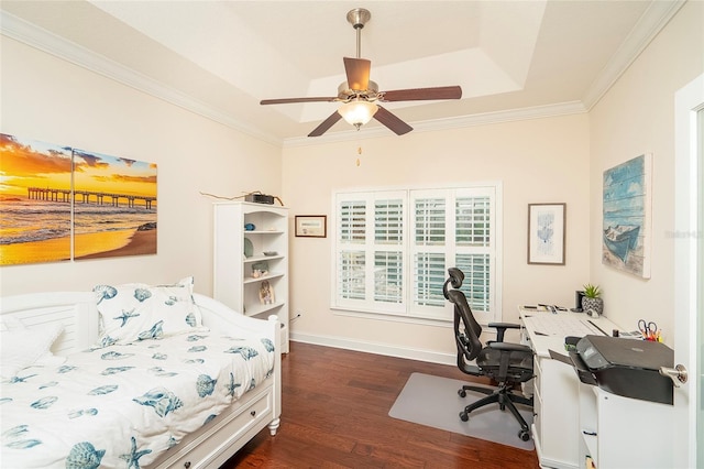 bedroom featuring a tray ceiling, ornamental molding, dark hardwood / wood-style floors, and ceiling fan