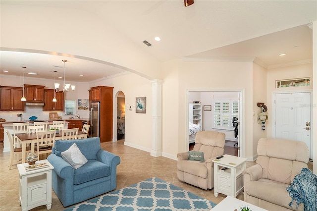 tiled living room featuring decorative columns, crown molding, lofted ceiling, and an inviting chandelier