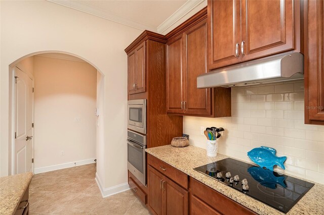 kitchen with light tile patterned floors, appliances with stainless steel finishes, backsplash, ornamental molding, and light stone countertops