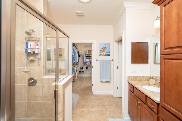 bathroom with tile patterned flooring, vanity, ornamental molding, a textured ceiling, and a shower with shower door