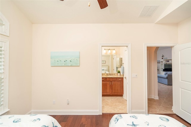 bedroom featuring hardwood / wood-style flooring, sink, connected bathroom, and ceiling fan