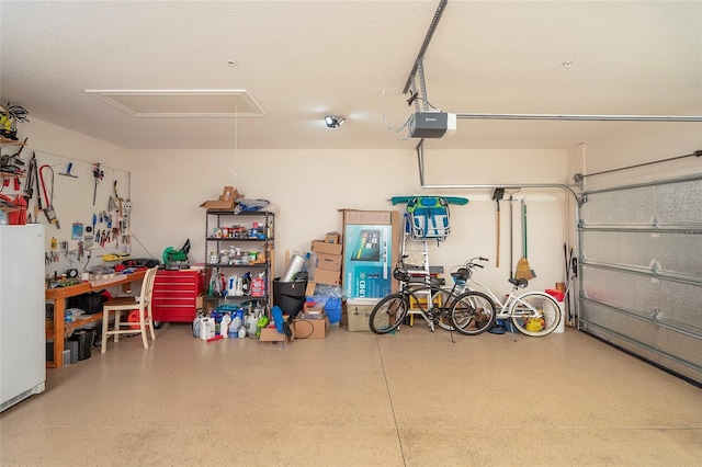 garage with a garage door opener, a workshop area, and white fridge