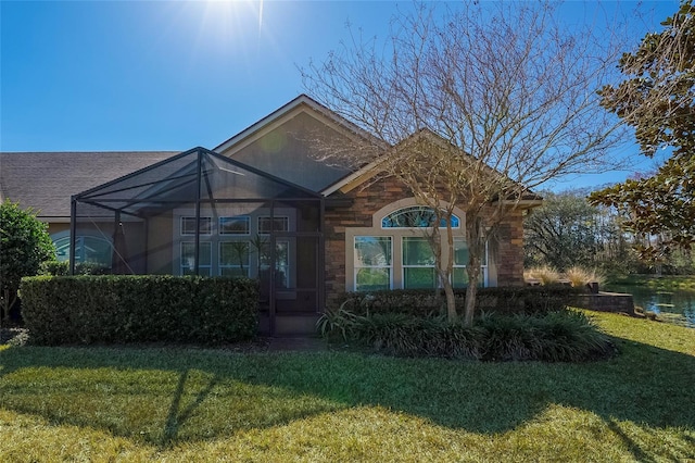 view of front of house with a front yard and glass enclosure