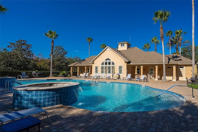 view of pool featuring a hot tub, a patio, and pool water feature