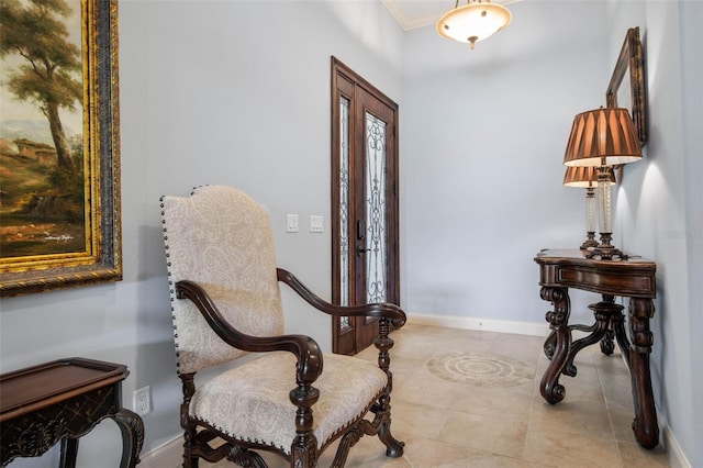 sitting room with baseboards, crown molding, and tile patterned floors