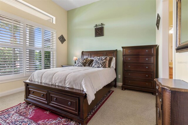 bedroom with light carpet and baseboards