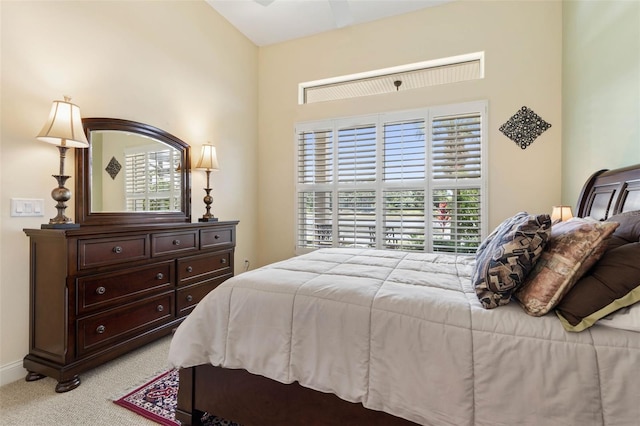 bedroom featuring light colored carpet and baseboards