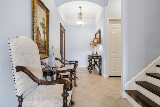 interior space with arched walkways, crown molding, light tile patterned floors, baseboards, and stairs