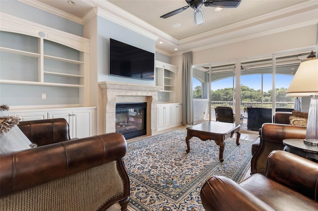 tiled living room with built in shelves, crown molding, recessed lighting, a premium fireplace, and a ceiling fan