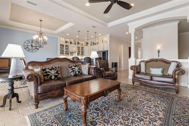 living room featuring a tray ceiling, decorative columns, visible vents, and a ceiling fan