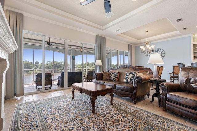 living room featuring ornamental molding, a raised ceiling, visible vents, and ceiling fan with notable chandelier