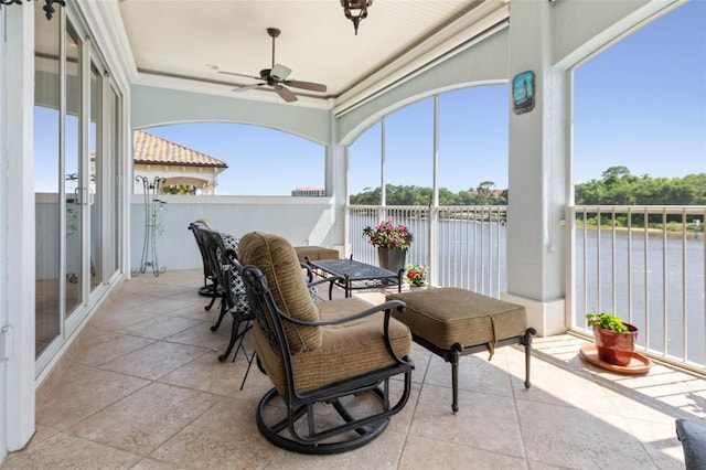 balcony featuring a water view and ceiling fan