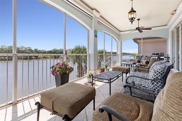 sunroom / solarium with a water view and a ceiling fan