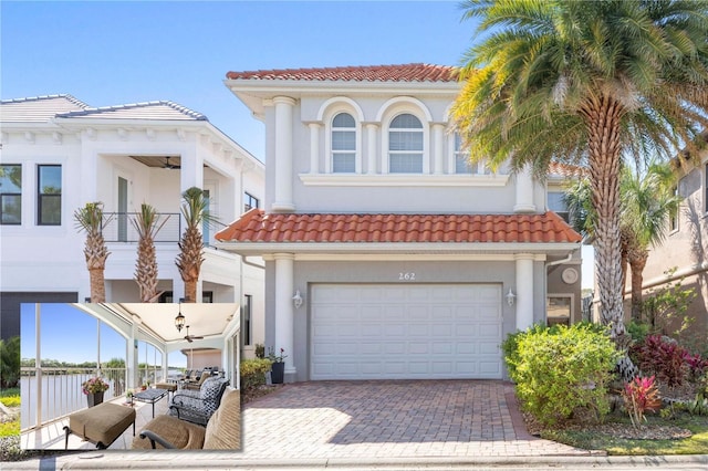 mediterranean / spanish house featuring a garage, a tiled roof, decorative driveway, and stucco siding