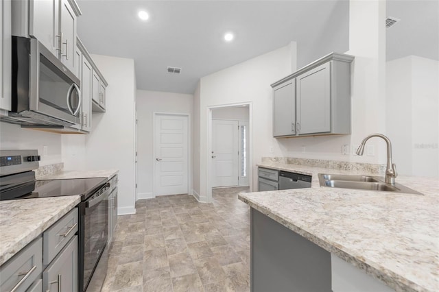 kitchen with appliances with stainless steel finishes, sink, and gray cabinetry