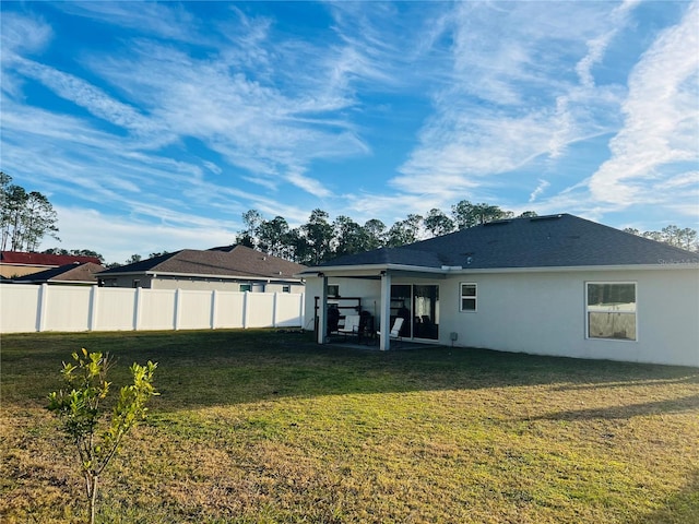 back of house featuring a patio and a yard