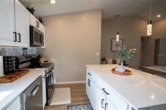 kitchen with white cabinetry, pendant lighting, wood-type flooring, and appliances with stainless steel finishes