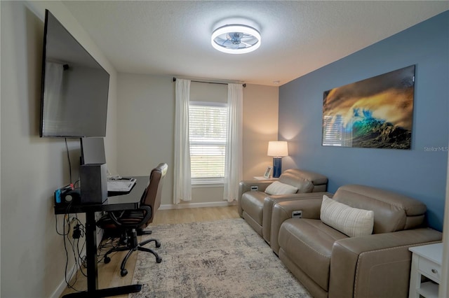 office area with light hardwood / wood-style flooring and a textured ceiling